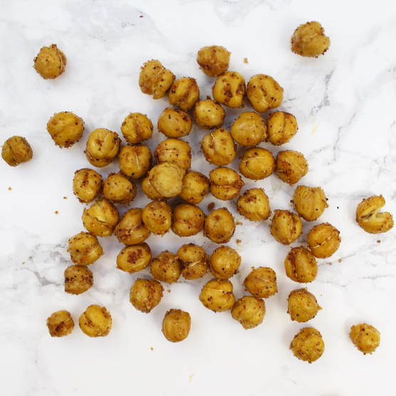 Crispy seasoned chickpeas on white marble backdrop.