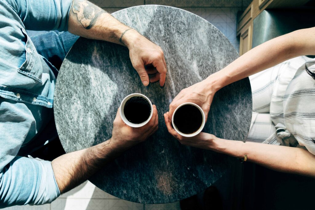 Two people sitting at round table with coffee