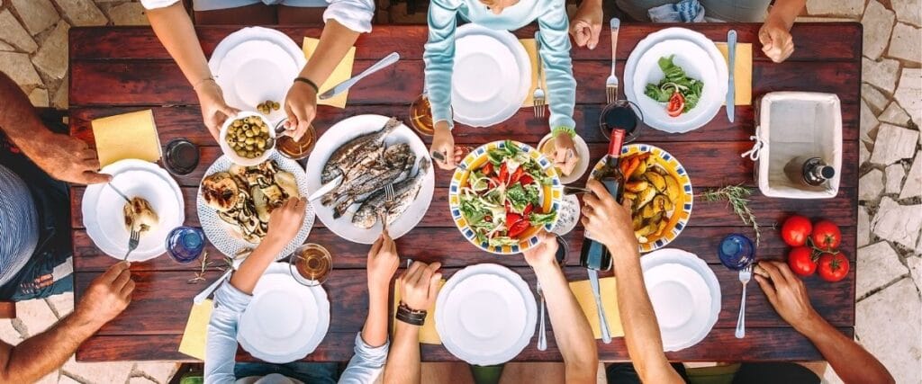 Bird's eye view of family eating at wood table.