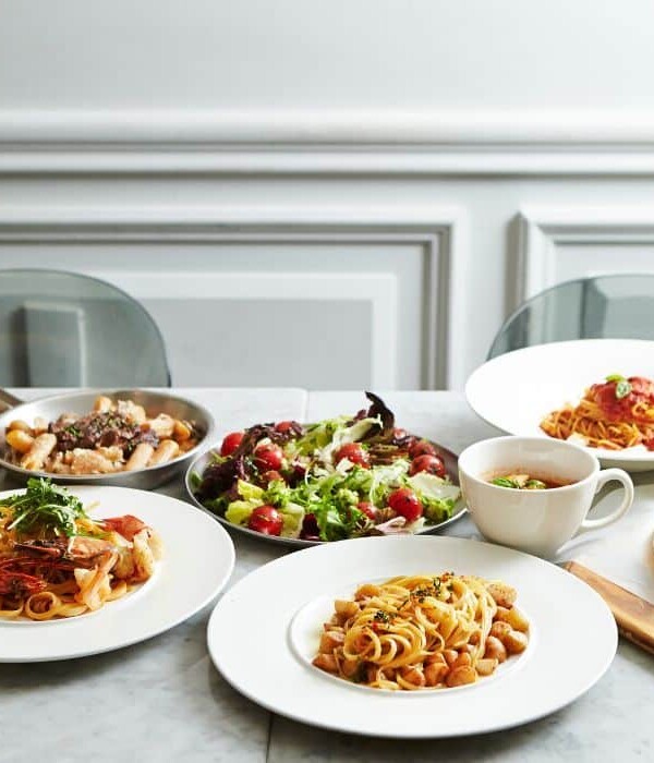 Food options including pasta, salad, pizza and soup on marble tabletop.