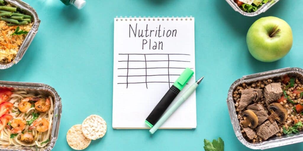 ADHD diet plan journal that says "nutrition plan" on blue background with food around it.