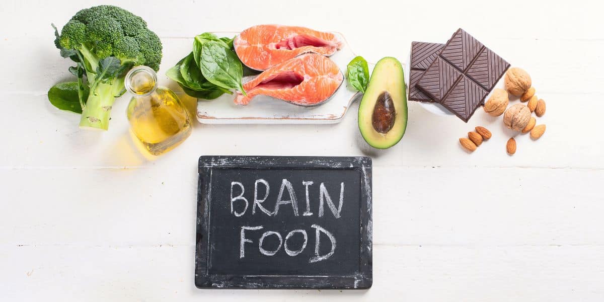 Chalk board that says "brain food" with healthy foods for an ADHD diet overtop.