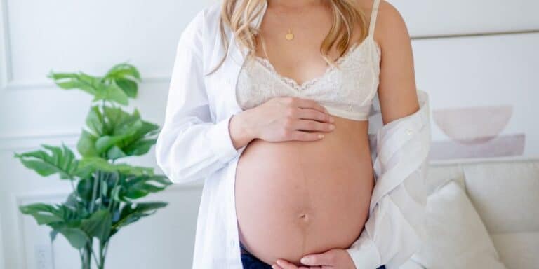 Pregnant woman holding belly.