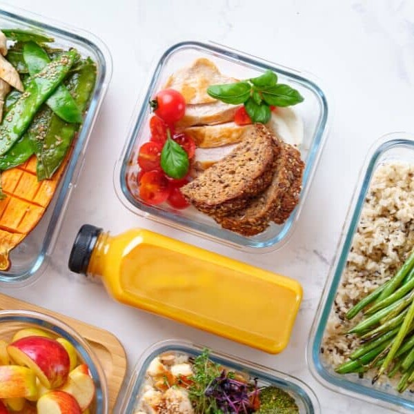 50 ADHD-friendly recipes main image. Healthy meals and smoothies in glass containers on grey surface.