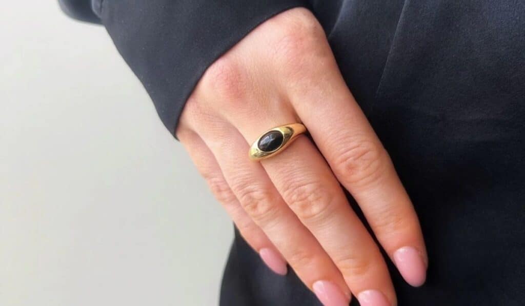 Black and gold fidget ring on a hand.