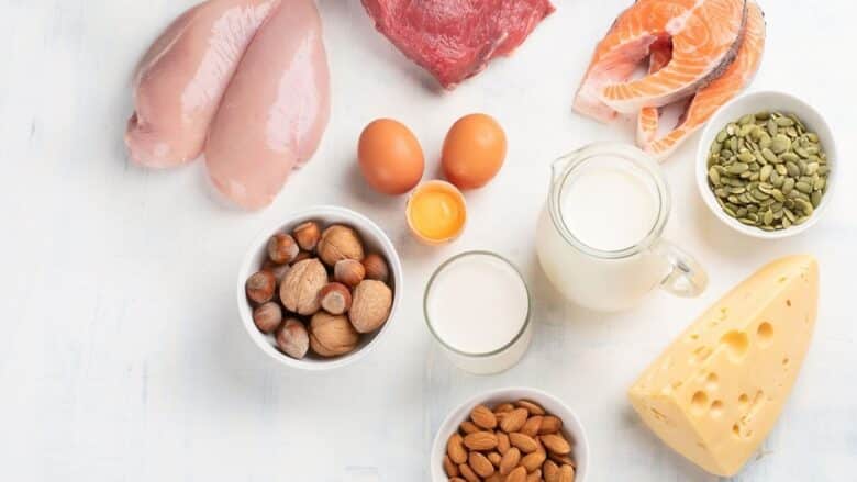 Overhead image of high protein foods including chicken, steak, eggs, chestnuts, almonds, and milk.