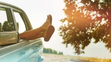 Car with feet coming out the window.