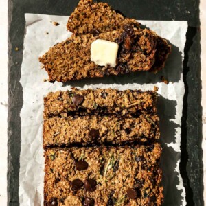 Overhead view of zucchini oatmeal bread sliced with butter on one piece.