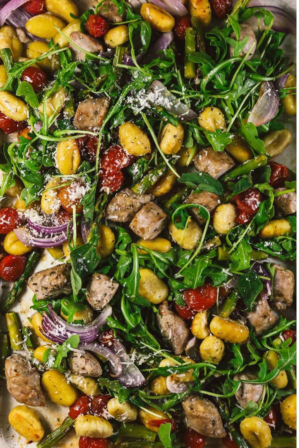 Close-up of cooked sheet pan gnocchi with sausage and vegetables on a pan