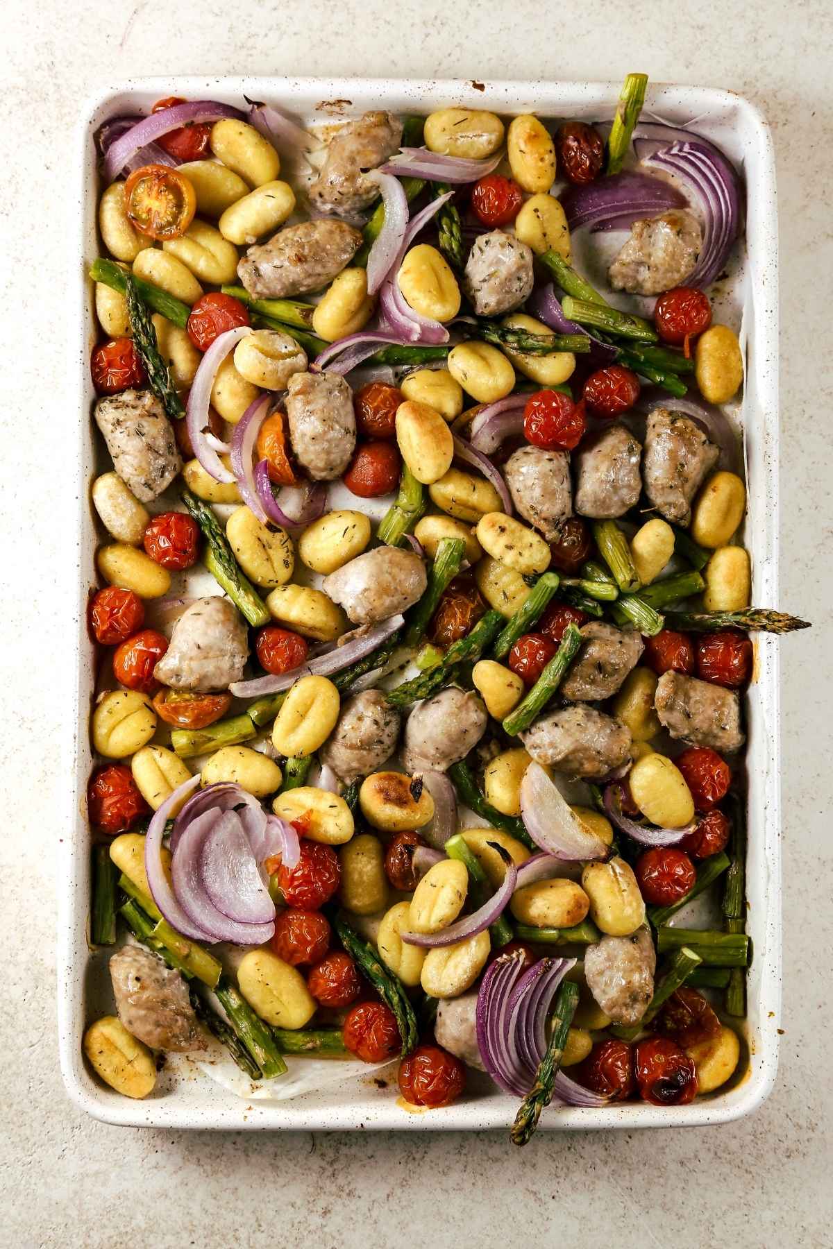 Sheet pan gnocchi with sausage and vegetables cooked on a pan.