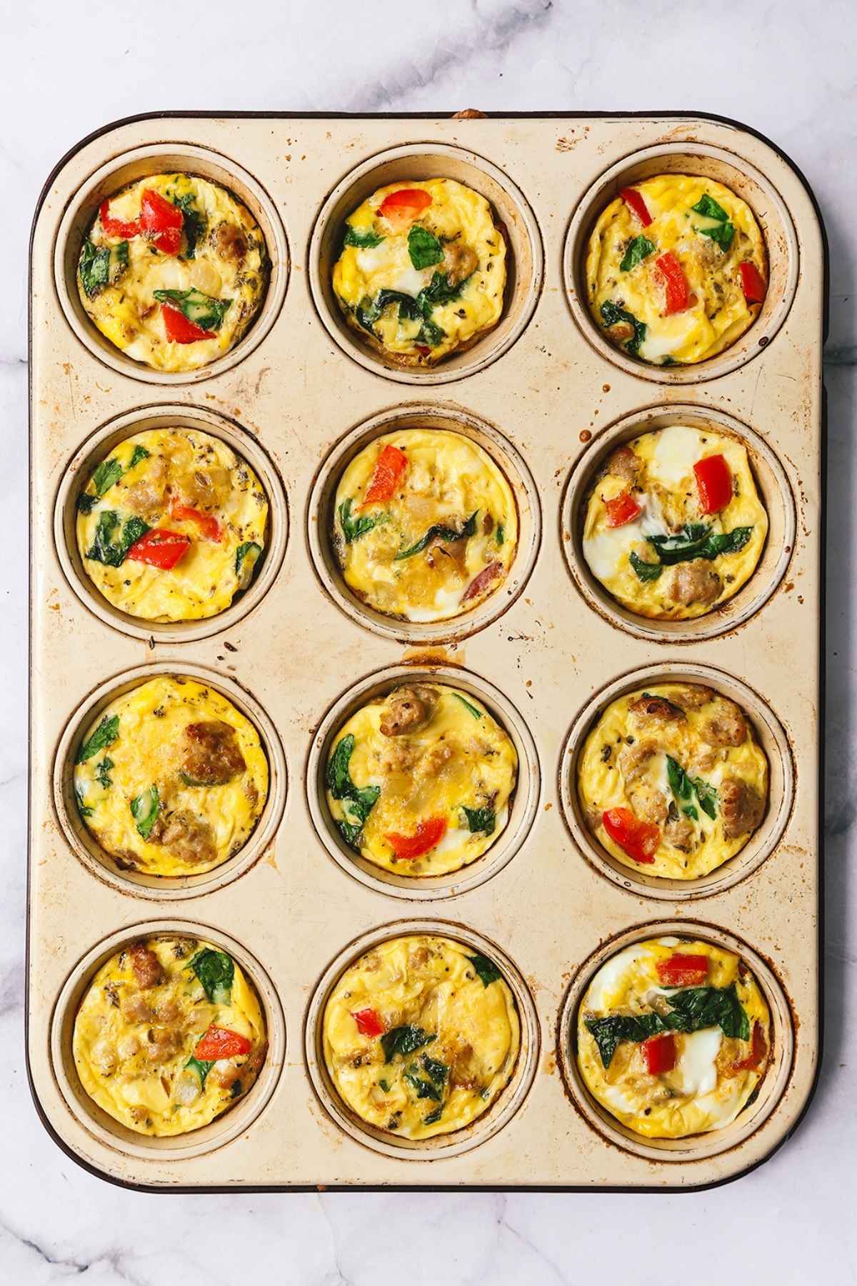 Overhead image of sausage egg bites in a muffin tin.